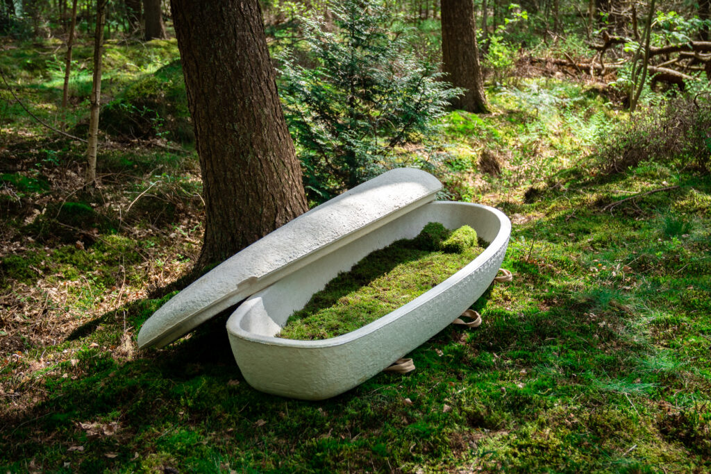 Image of the Loop Living Cocoon in the forest with an open lid, showing the moss lining.